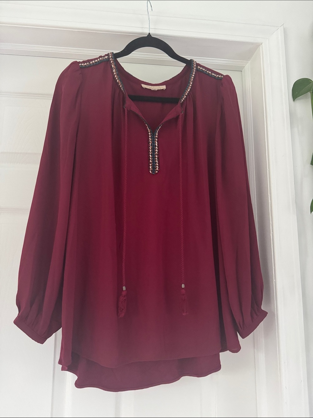 Burgundy V-neck tunic blouse with embroidery and a split neckline with ties.